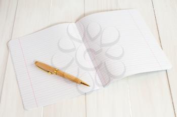 A blank exercise book jotter with pen