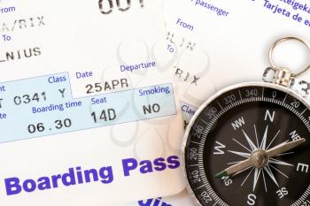 Air travel boarding pass and compass, close-up