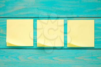Wooden wall with three blank  sticky notes