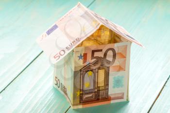 House made of Euro banknotes on a wooden background