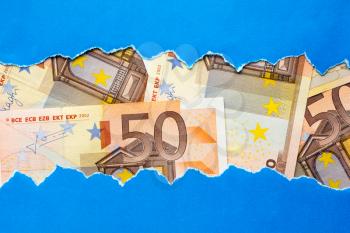 Fifty Euro bills in torn blue paper frame