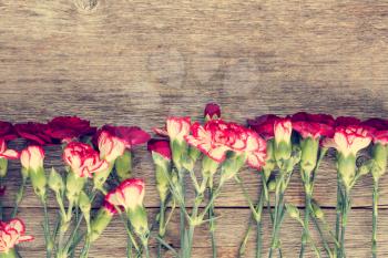 Carnations on old wooden background with copy-space