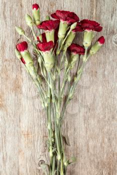  Bouquet of red carnations on the old  wooden background 