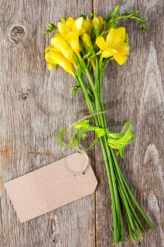 Bouquet of freesia flowers  with blank tag tied with string