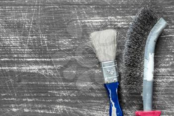  Paintbrush and wire brush on the wooden background with copy-space