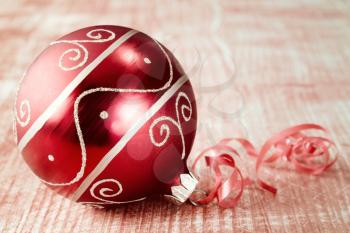 Christmas ball with ribbon on wooden background