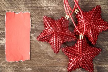 Red Christmas stars with blank piece of paper for greeting text