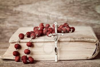Close-up of prayer book and rosary on wooden background