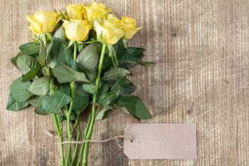Bunch of yellow roses with blank tag tied with string
