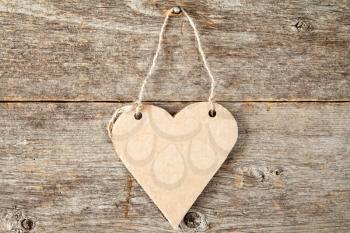Heart shaped paper signboard on the old wooden background