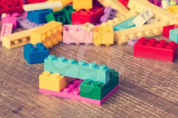 Colored toy bricks on the wooden surface