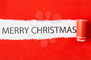 Merry Christmas message appearing behind torn paper