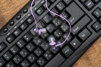 Computer keyboard and earphones. A representaion of an environment of technology and objects