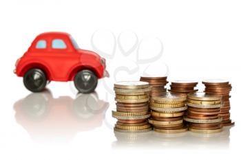 Saving for a new car. Coin stacks in front of car on white background