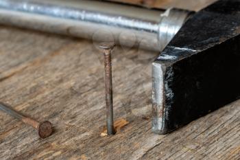 Vintage old hammer with rusty nails on wood table background 