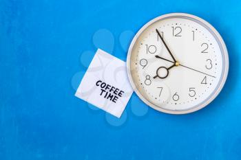 Wall clock with COFFEE TIME note on napkin
