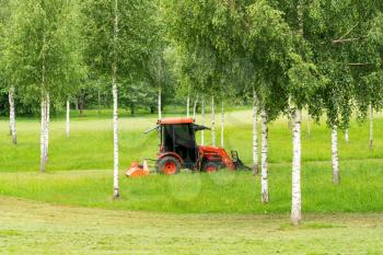 Tractor mowing grass in the city park