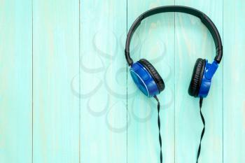 Stereo headphones on blue wooden background with copy-space