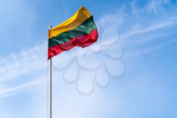 Lithuanian flag waving on the blue sky background