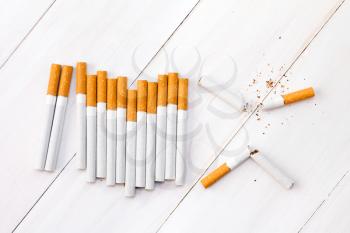 Broken cigarettes on white wooden background (Quit smoking today).
