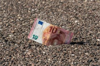 Ten Euro bill in the pavement crack