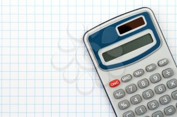 Electronic digital calculator on squared paper background