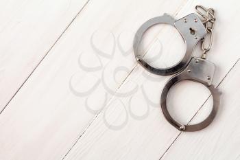 Metal handcuffs on the wooden background,copy-space