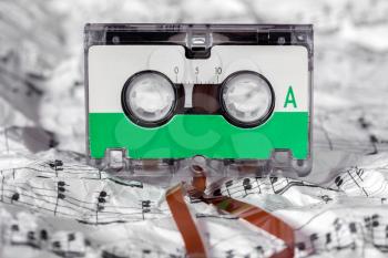 Audio cassette on the crumpled music sheet