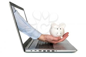 Hand holding piggy bank comes from laptop screen
