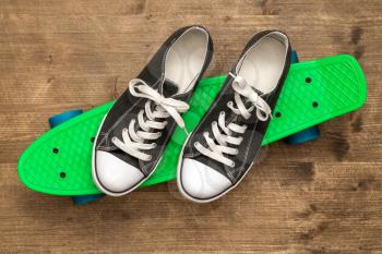 Pair of black sneakers on a green skateboard