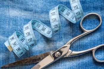  Jeans,measuring tape and scissors.Concept of healthy lifestyle and losing weight