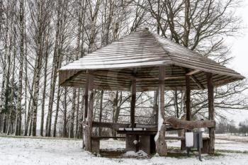 Gazebo, covered with snow on the background of the winter landscape