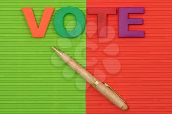 The word Vote with with a pen lying on the contrast background