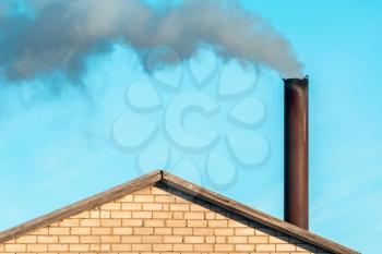 Smoke comes from the chimney of the house. Smoking chimney smoke pollution.