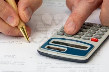 Close up on accountant hand pressing on calculator for calculate monthly benefits , business concept