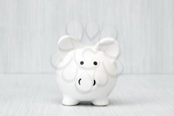 White Piggy bank on wooden table with copy space