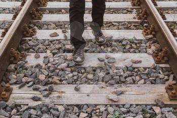 Man walking on the railway tracks, posing a threat to trains and themselve
