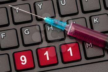 Computer keyboard with syringe and emergency number 911