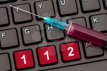 Computer keyboard with syringe and European emergency number 112