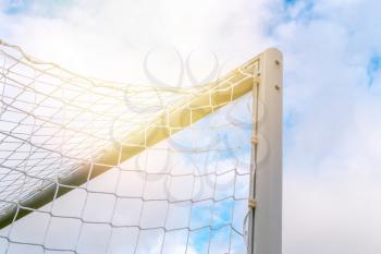 Corner of metal football gate on blue sky sunny background