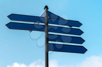 Blue Blank directional Signs over cloudy Sky