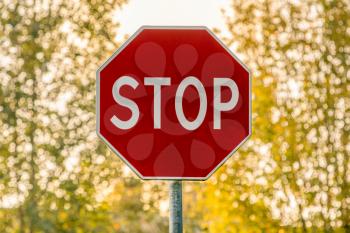 A red stop sign on a nature background. Stop and give way