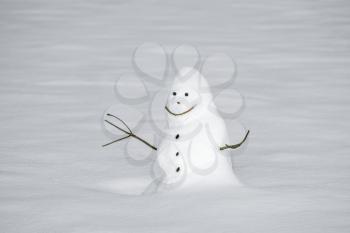 Snow sculpture. In winter, games in nature.Happy snowman standing in snowdrift.