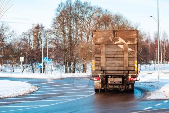 Truck at the roundabout in snowy and icy season. Danger driving.