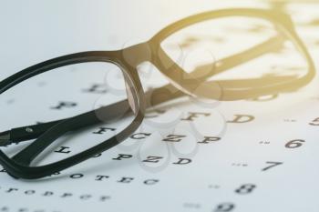 Modern reading glasses on the eye sight test chart