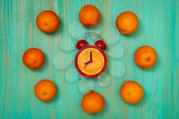 Red alarm clock with a fresh orange dial.Healthy Eating Time.