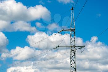 Iron tower with wires electricity transmission on the summer sky background