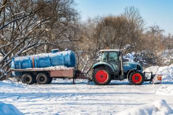 Tractor with tanker for cleaning the sewer system. Winter season.