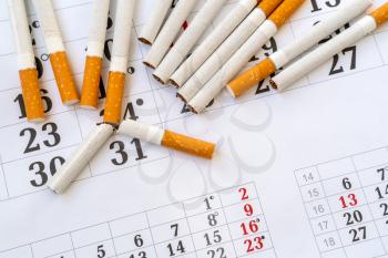Quit smoking - today! The broken cigarette on a calendar. World No Tobacco Day Concept Stop Smoking. 