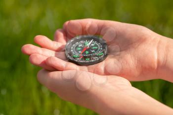 Old classic navigation compass on a children's hands. How to navigate the compass
